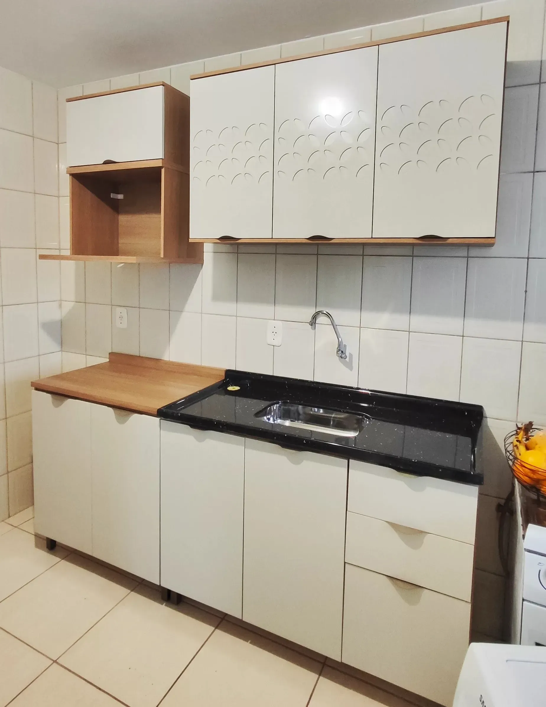 Armários de cozinha brancos e balcão com pia montados. Serviço de montagem de móveis convencionais.